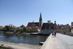 Steinere Brücke mit Blick auf die Stadt und ihren markanten Türmen neben der Donau.