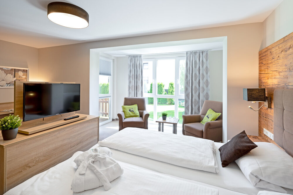 Geräumiges Doppelzimmer-Premium-Plus mit einem großen Bett und einem Flachbildschirm im Richstein's Posthotel.