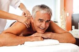 Ein Mann erhält eine wohltuende Massage im Wellnessbereich vom Johannesbad in Bad Füssing.