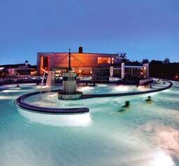 Eine in der Dunkelheit illuminierter Pool in der Europa Therme Bad Füssing.