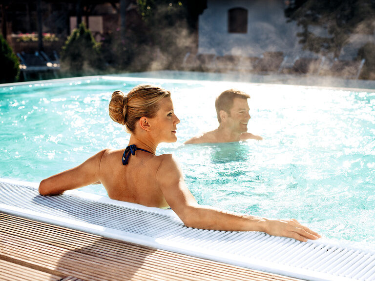 Das Thermalwasserbeecken eines Wellnesshotels bietet einem Paar Erholung und Freizeitvergnügen in Bad Füssing.